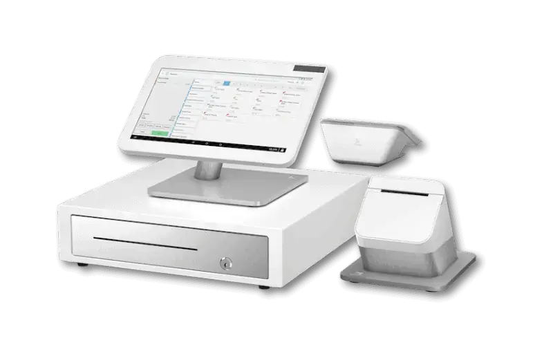 Modern countertop POS station with touchscreen display, cash drawer, and receipt printer for retail stores.