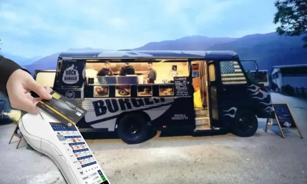 A mobile POS device processing a credit card payment in front of a food truck at dusk, showcasing an efficient and portable payment solution for food trucks.
